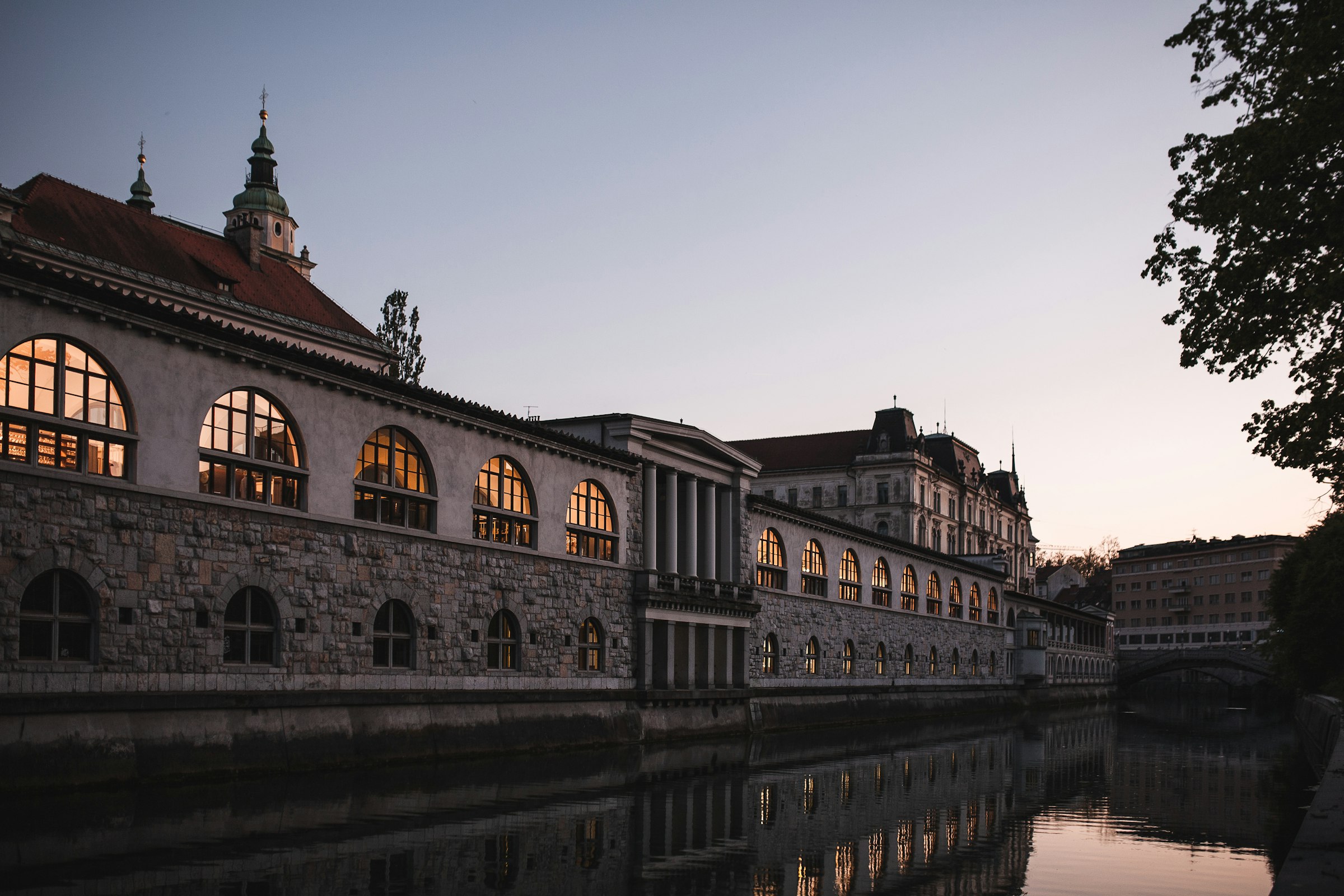 Ljubljana at dusk: Plečnik's market colonnade reflected in the Ljubljanica river